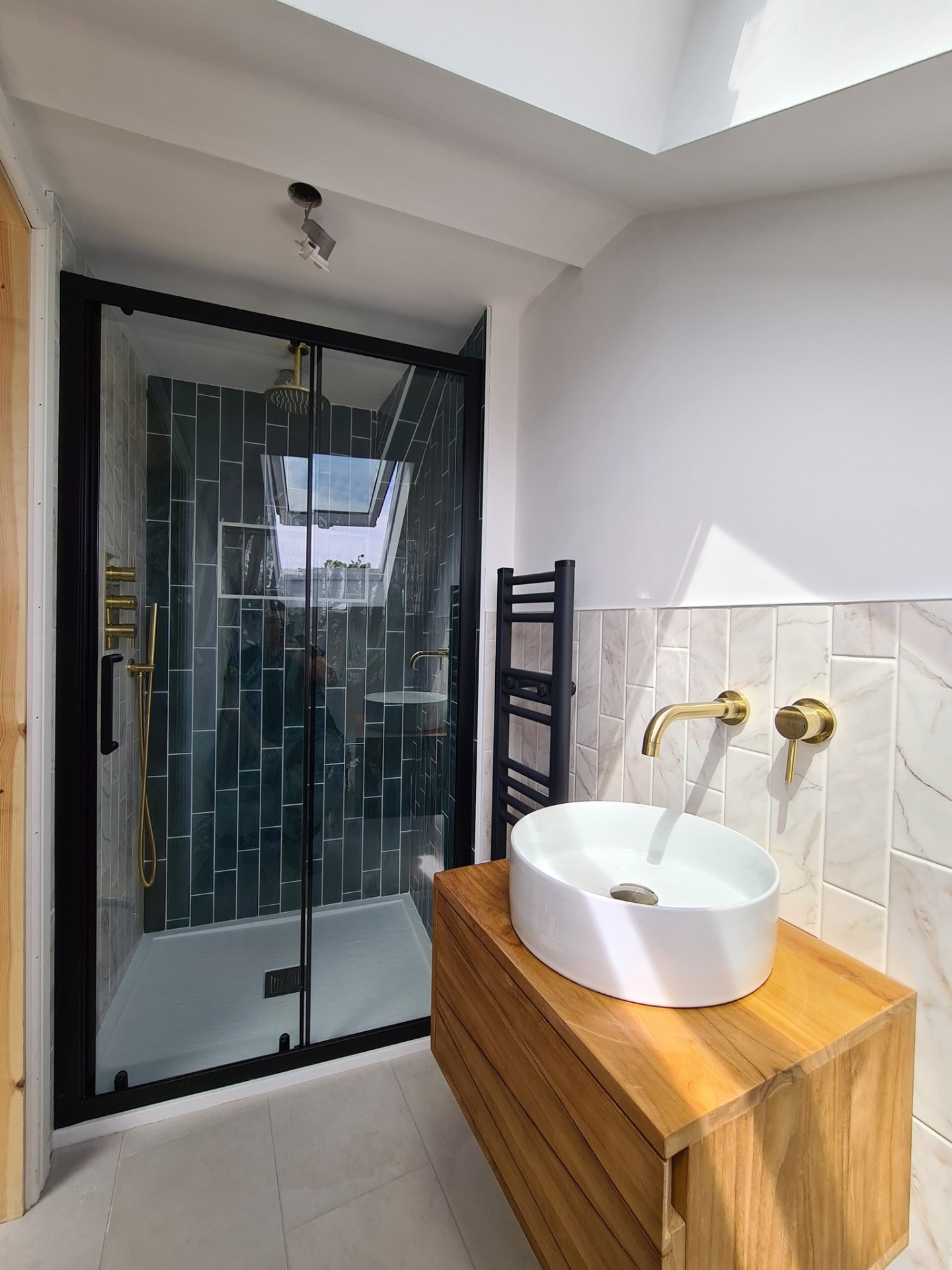 Walk-in shower enclosure with glass screen and vanity unit in modern bathroom