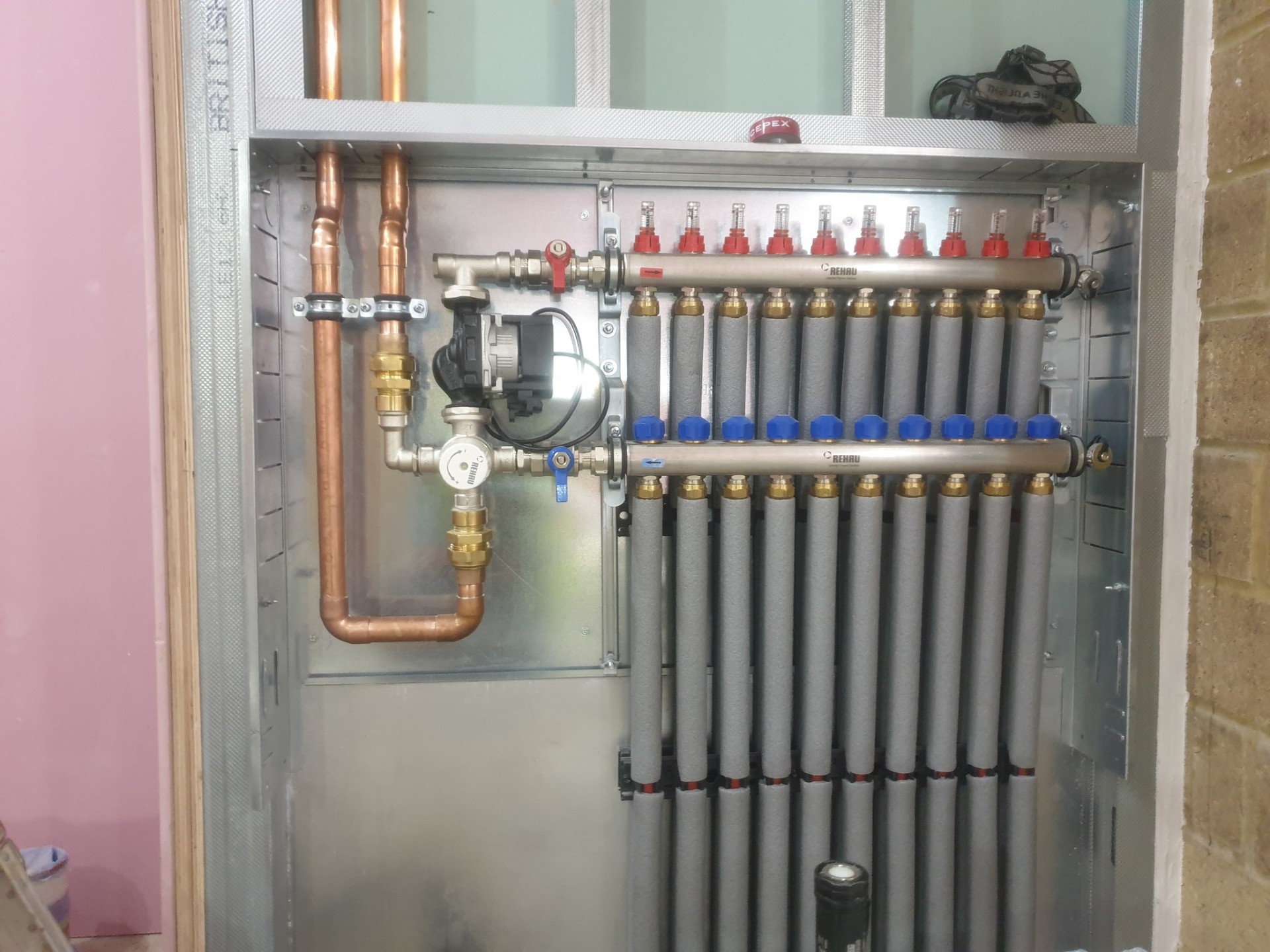 Underfloor heating manifold with copper supply pipes and zone valves